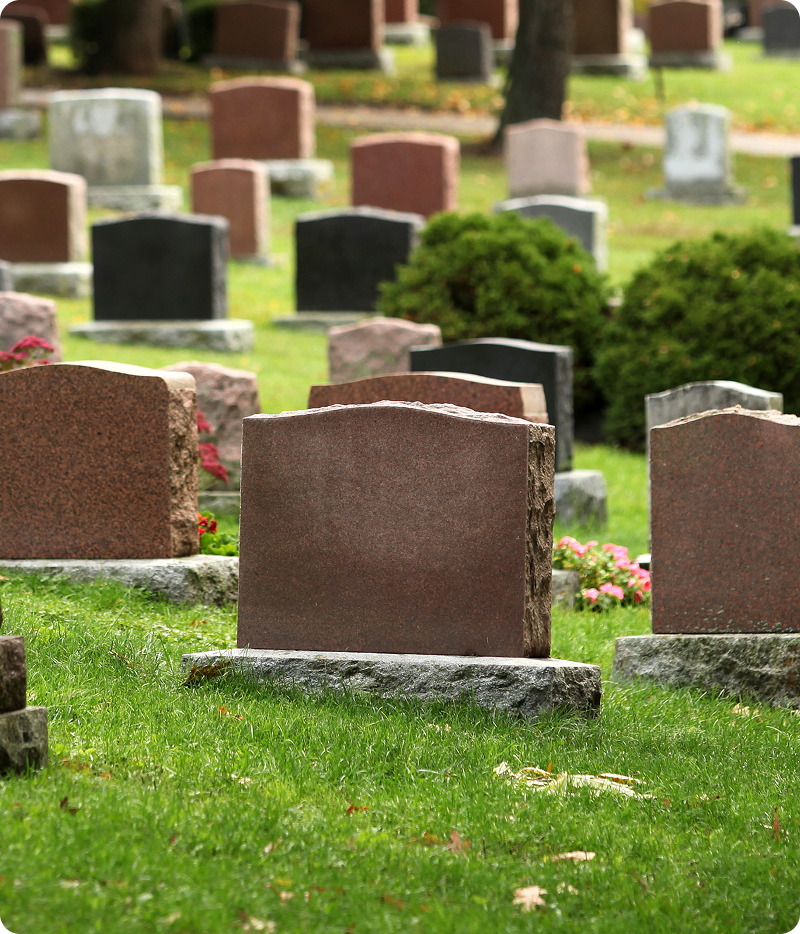 Gravestones in a green, peaceful cemetery.